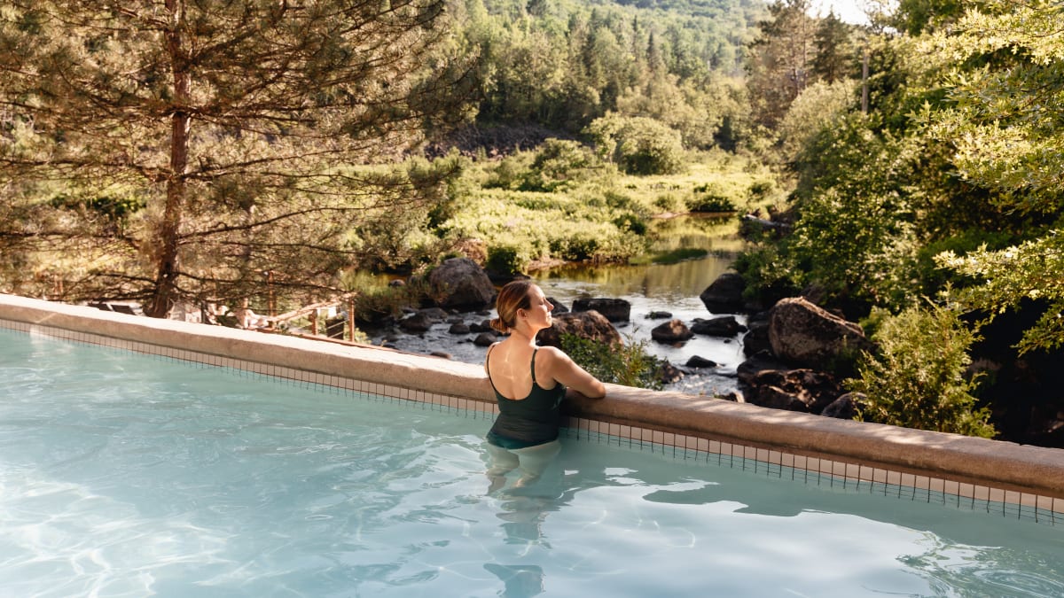 Woman contemplating nature in a thermal pool.