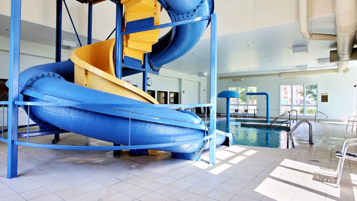 Indoor pool with blue and yellow slide at Super 8 Lachenaie.
