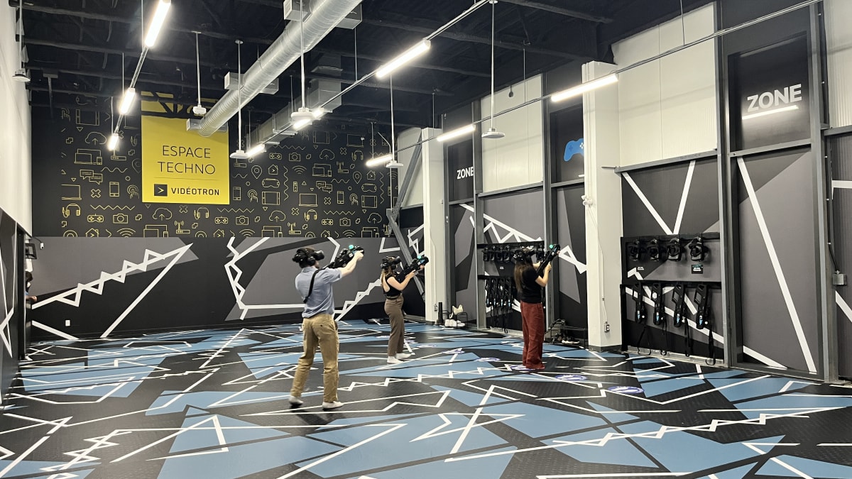 Trois personnes dans une arène de réalité virtuelle.