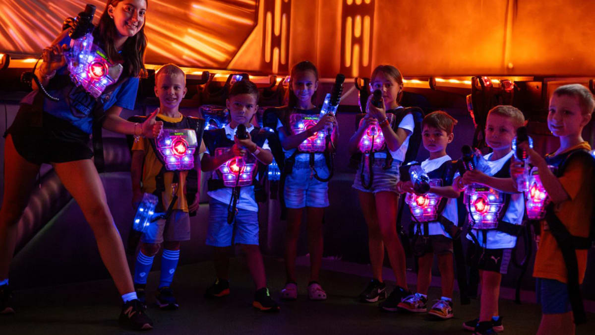 Monitrice avec sept jeunes enfants vêtus de gilets illuminés.