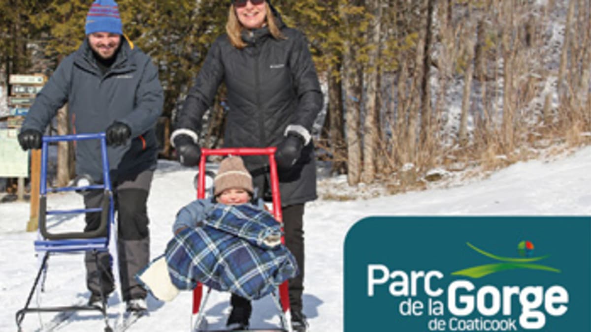 Deux parents et leur enfant explorant les sentiers en trottinette des neiges