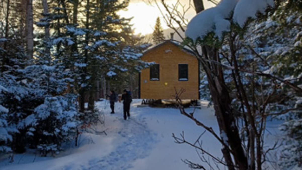 Deux randonneurs à l’extérieur d’un refuge en pleine nature