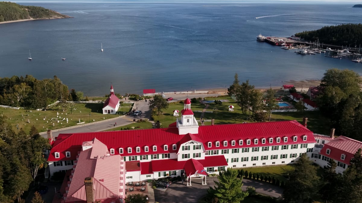 Vue aérienne d'un hôtel au toit rouge situé au bord de l'eau.