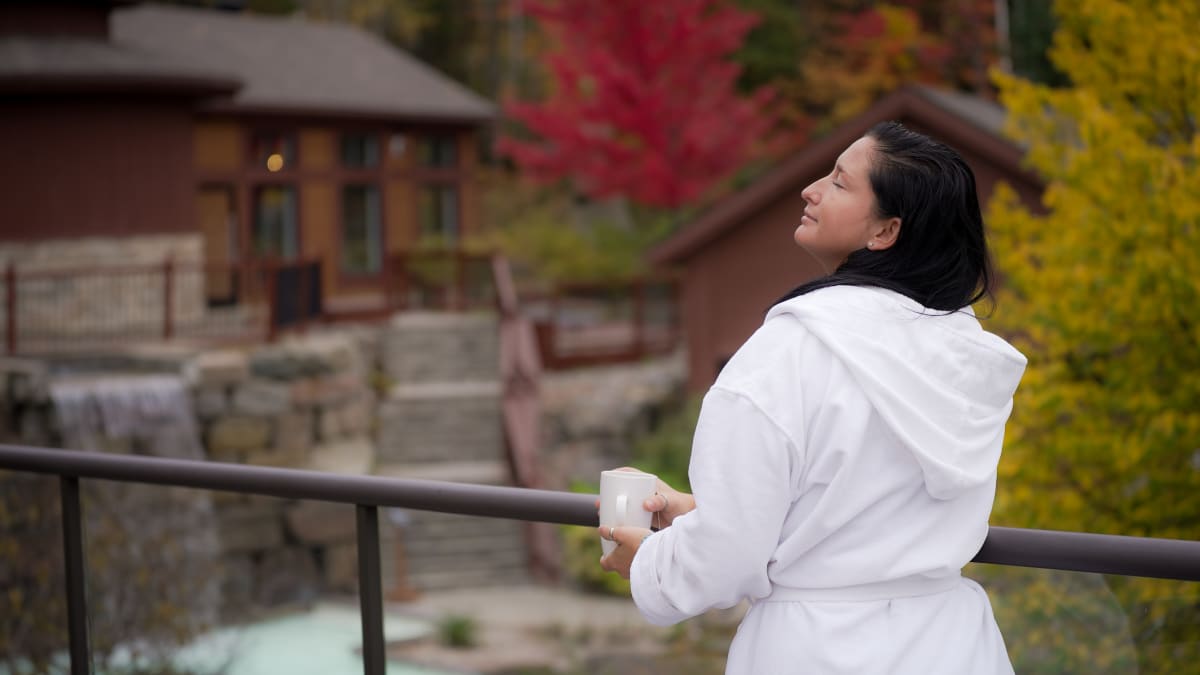 Femme en robe de spa sur le bord des installations thermales.