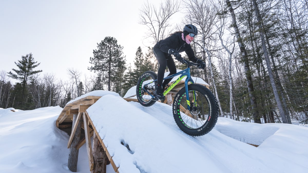 Femme en train de faire du fatbike dans la neige.