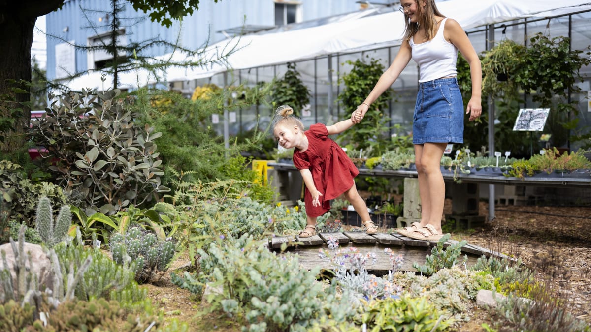 Two young girls observing a cactus and succulent garden.