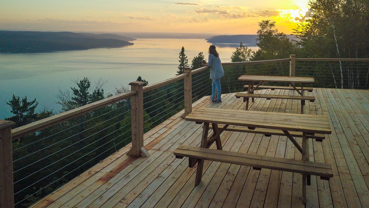 Femme sur une terrasse au bord de la rivière Saguenay au Cap à Leste.