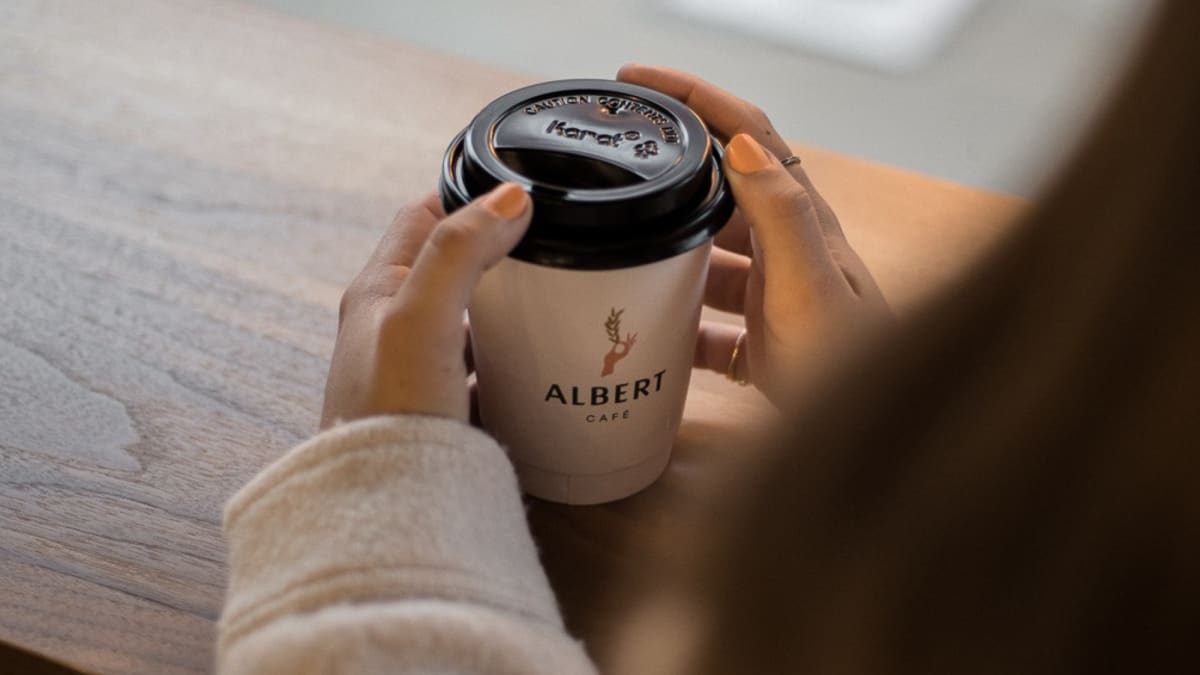 Une femme buvant un café à Albert Café et épicerie.