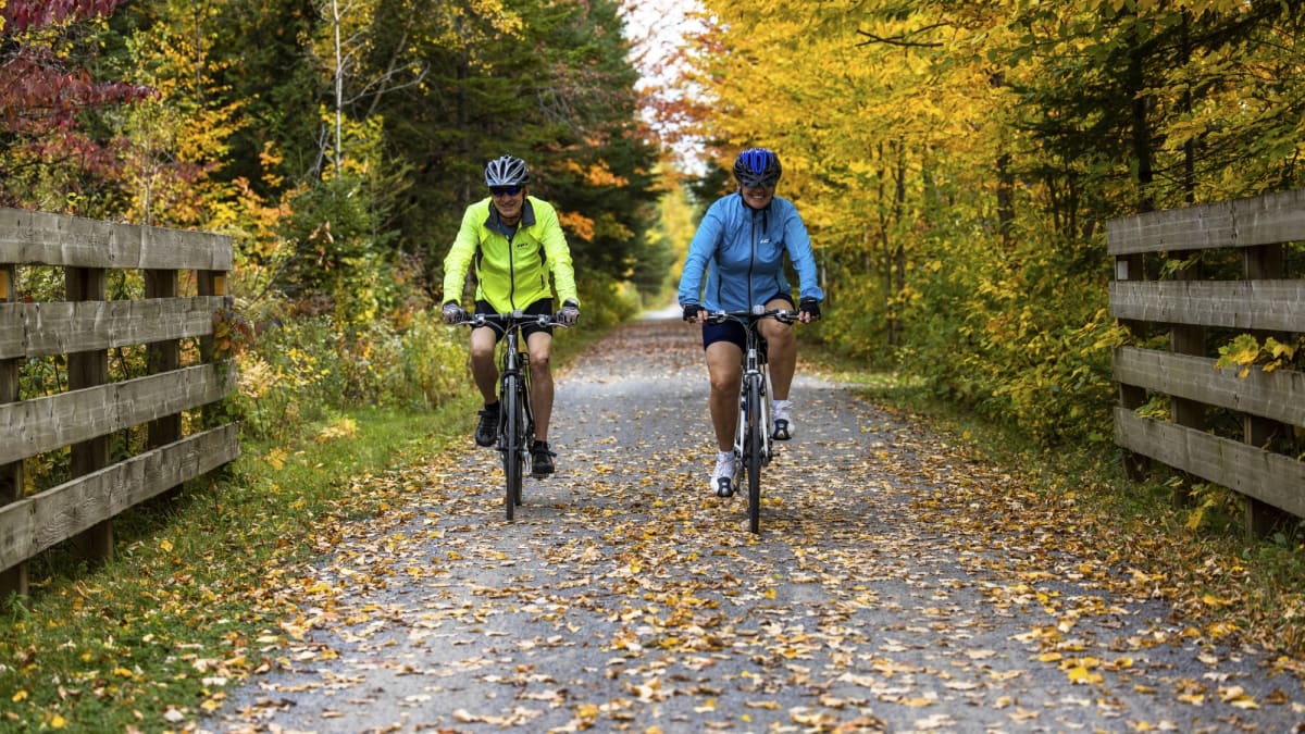 Couple on bicycles at Station touristique Duchesnay in the fall.