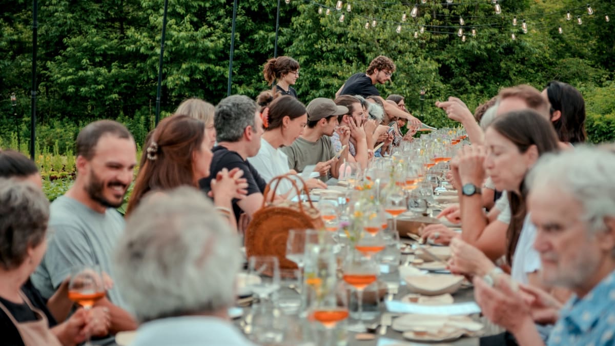A long table set up outdoors, where many guests are seated.