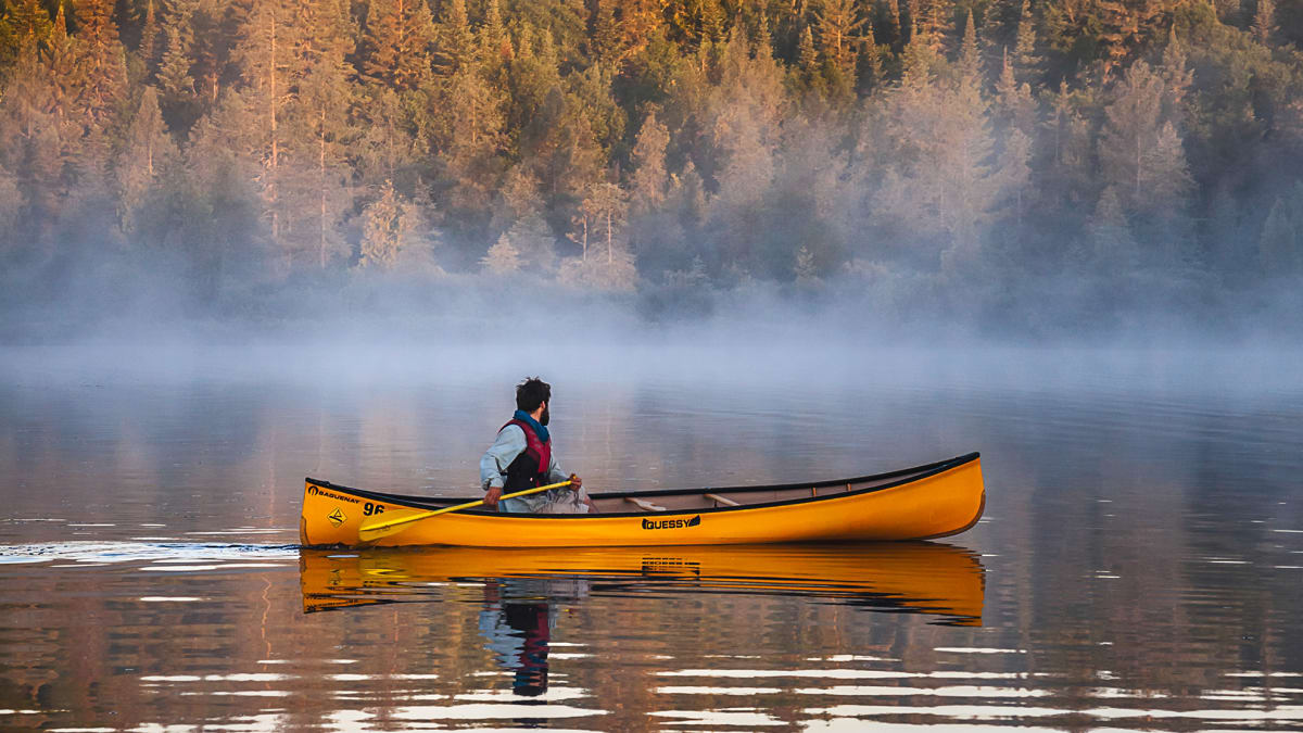 Canot jaune sur un lac brumeux en Abitibi-Témiscamingue.