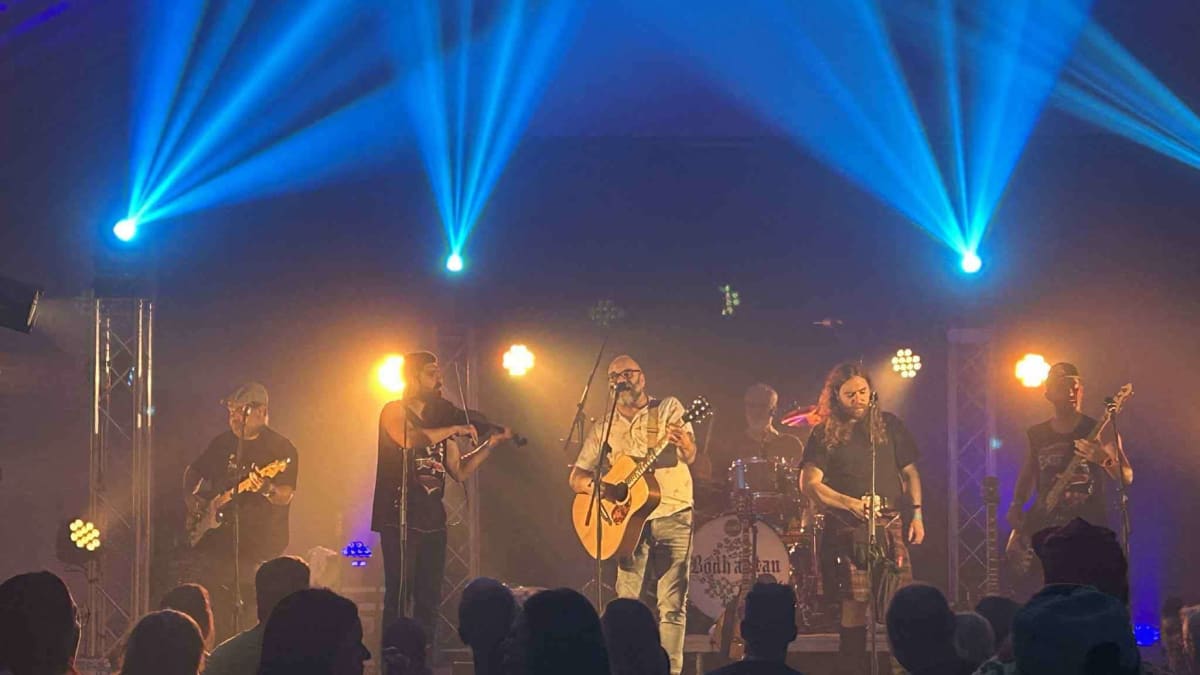 Groupe en train de performer sous les lumières bleutés lors du Festival du Fjord.