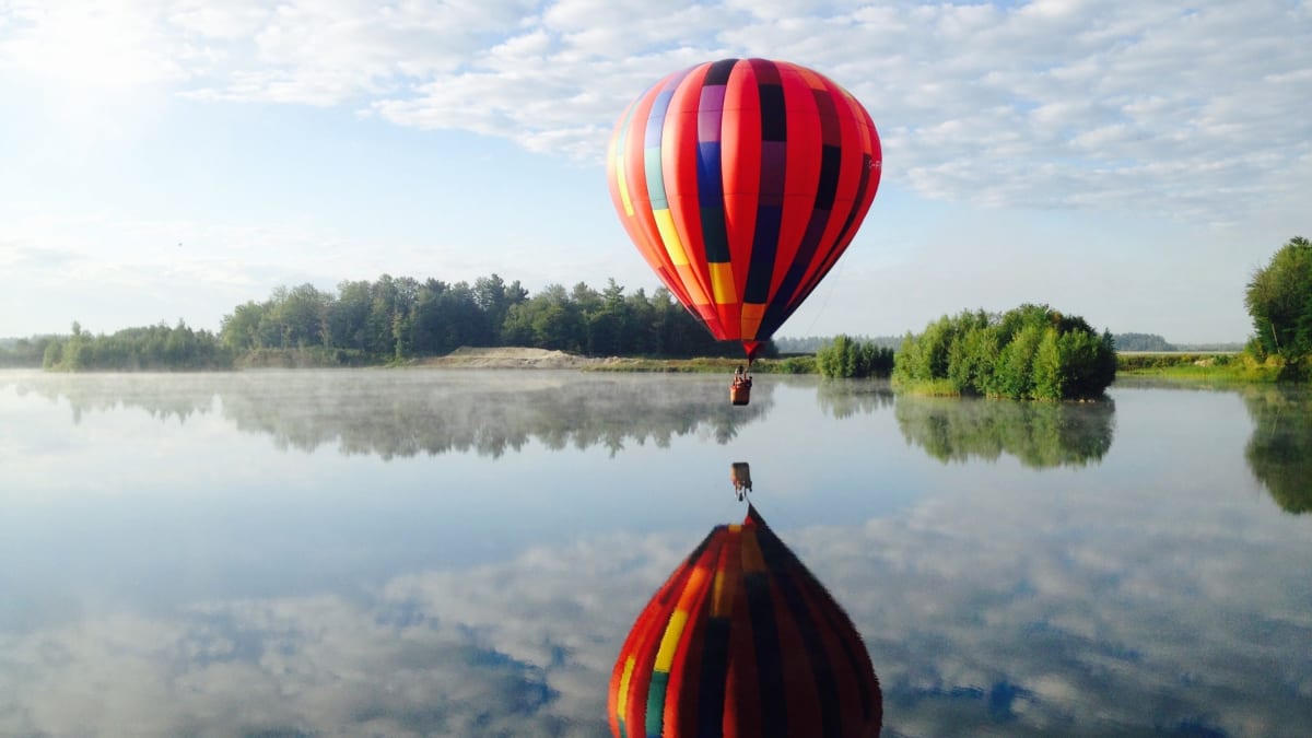 A hot-air balloon over a lake.