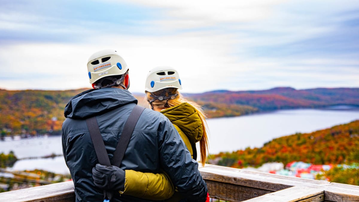 Couple, casque à la tête, avant une descente en tyrolienne.