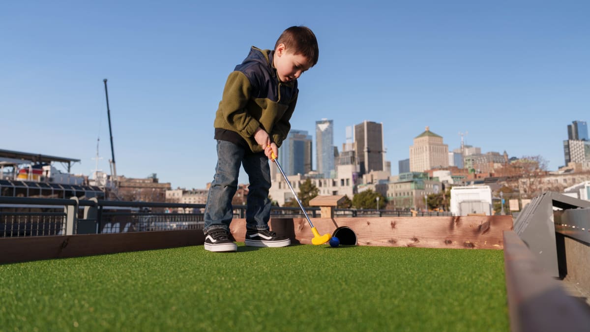 Jeune garçon en train de jouer au mini-golf