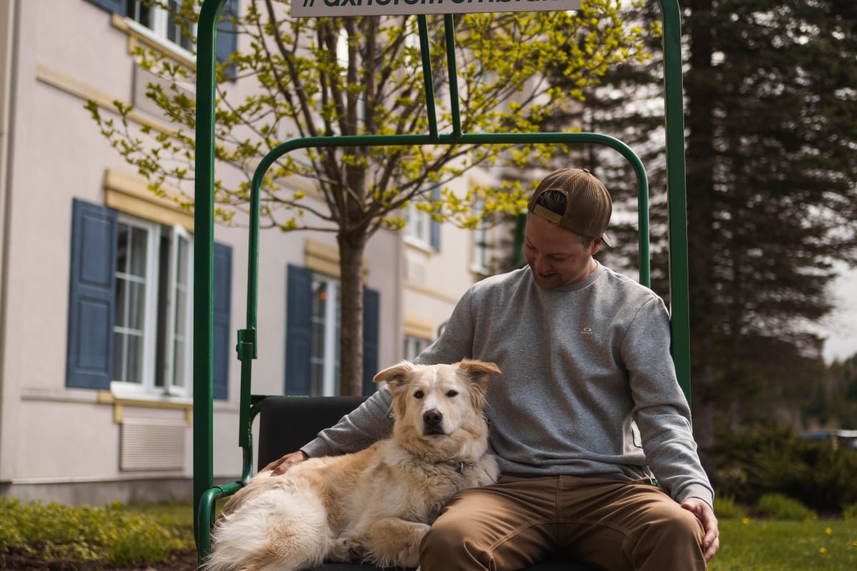 Homme et chien à l'extérieur de l'Ax Hôtel Mont-Tremblant.