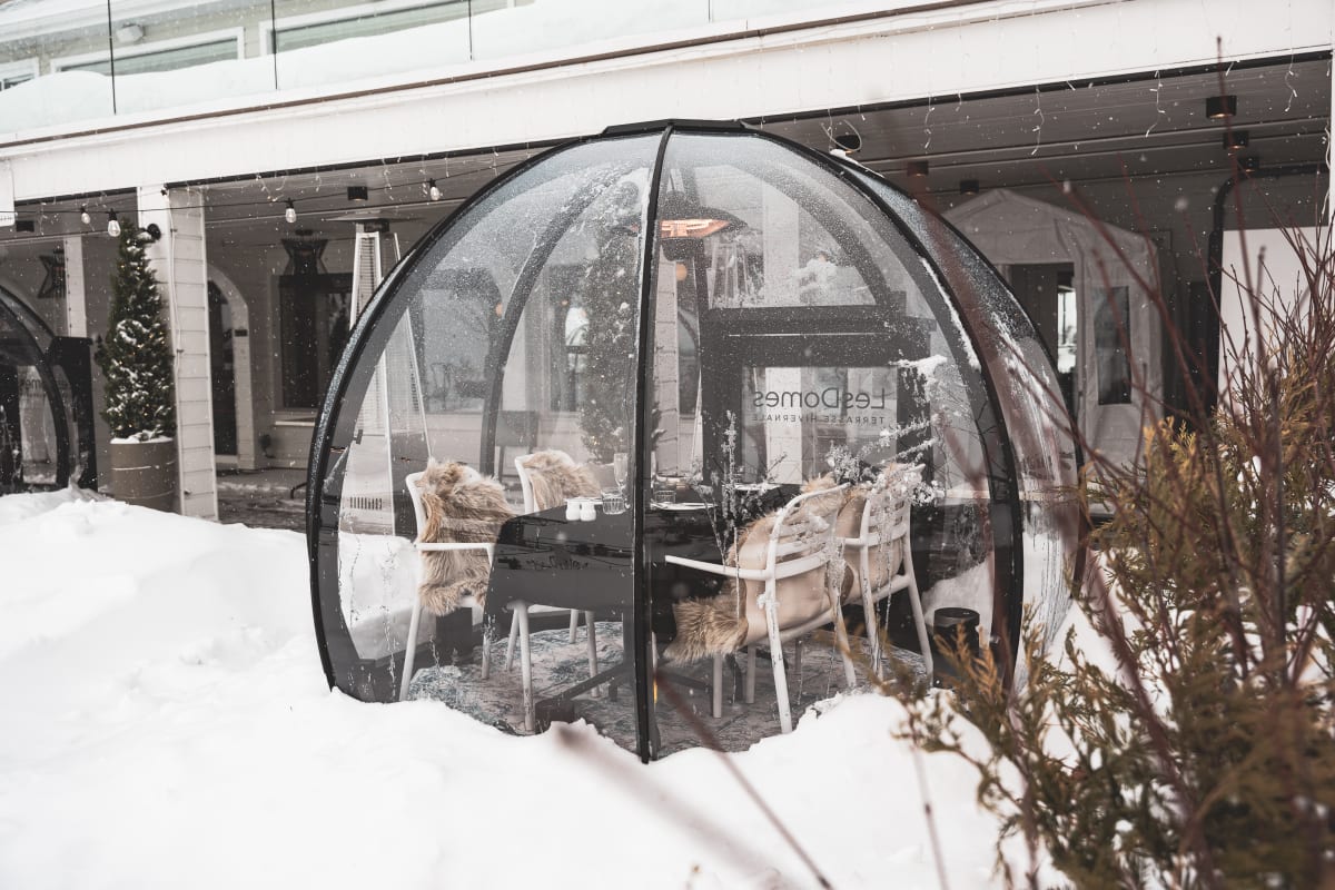 Table dans un dôme transparent en hiver au Bistro Koz. 