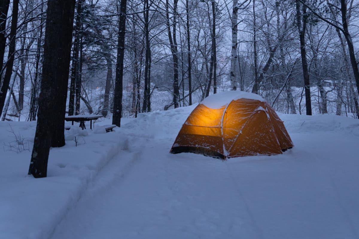 Tente de camping éclairé sur la neige