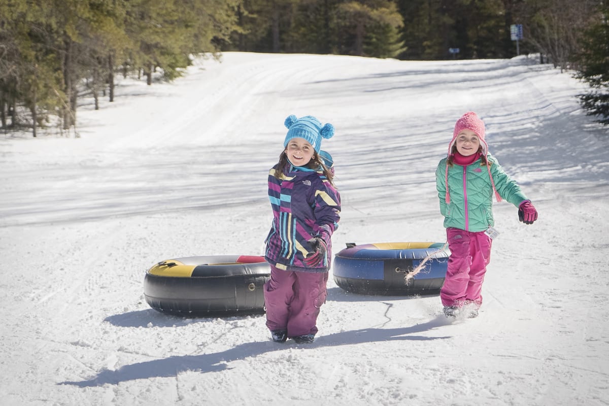 Deux filles qui font de la glissade sur tube dans Charlevoix.