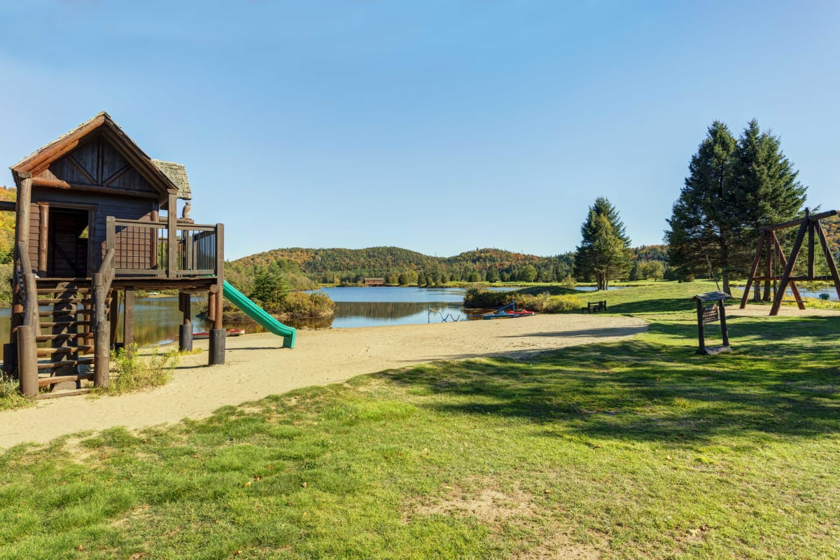 Parc pour enfant au bord d'un lac aux Chalets Royal Laurentien.