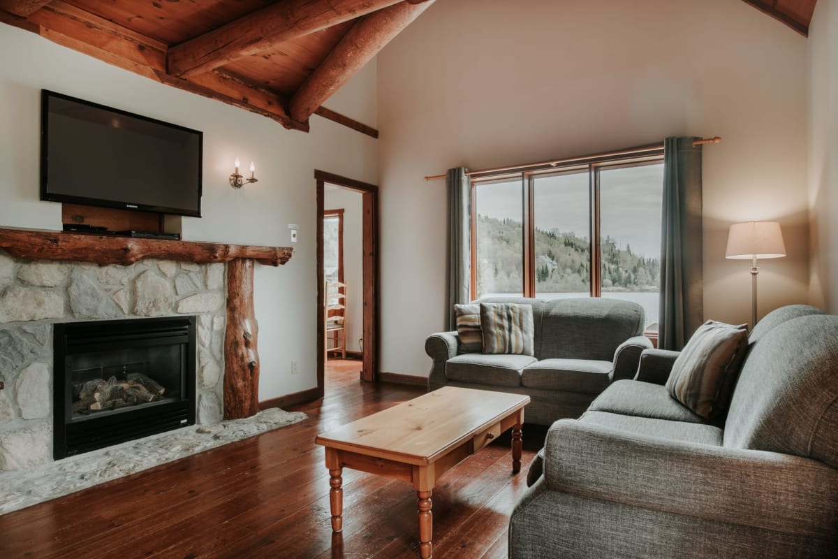 Salon avec divans et foyer dans un des Chalets Royal Laurentien.
