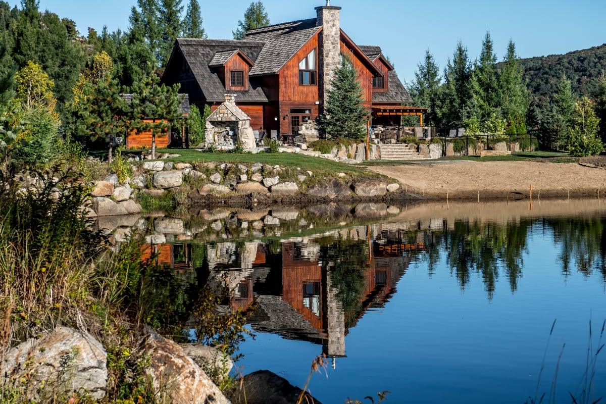 Extérieur d'une grande maison en bois et pierre aux Chalets Royal Laurentien.