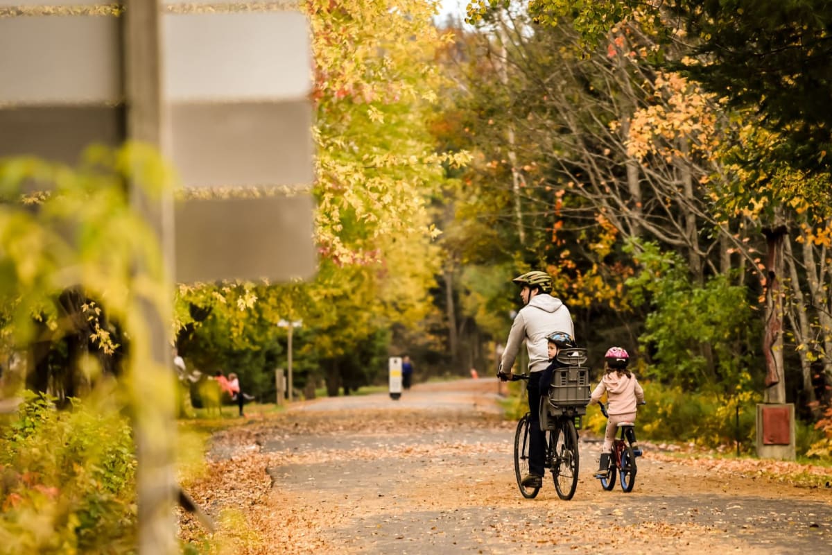 Famille à vélo en automne sur Le P’tit Train du Nord