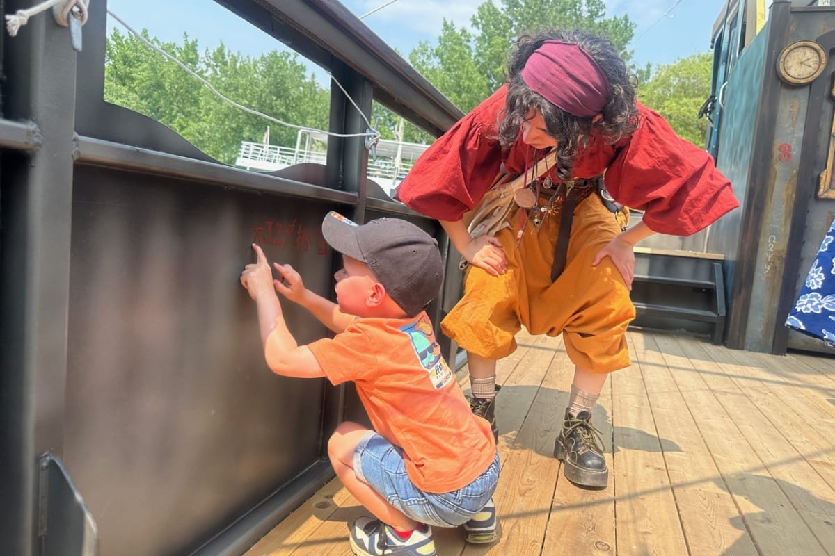 Enfant et animatrice en costume sur un bateau pirate.