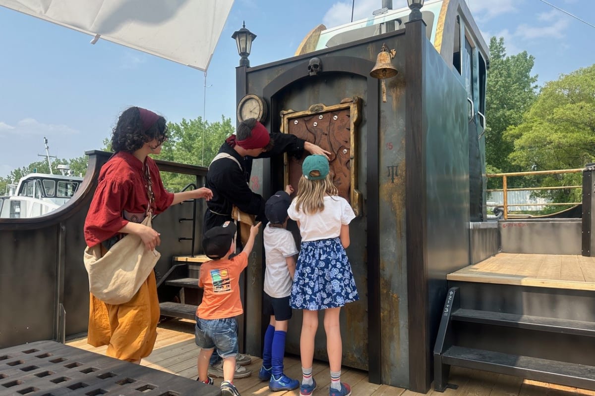 Groupe d'enfants et animateurs en costume sur un bateau pirate.