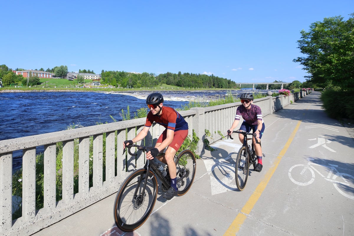 Deux cyclistes sur une piste cyclable au bord de l'eau.