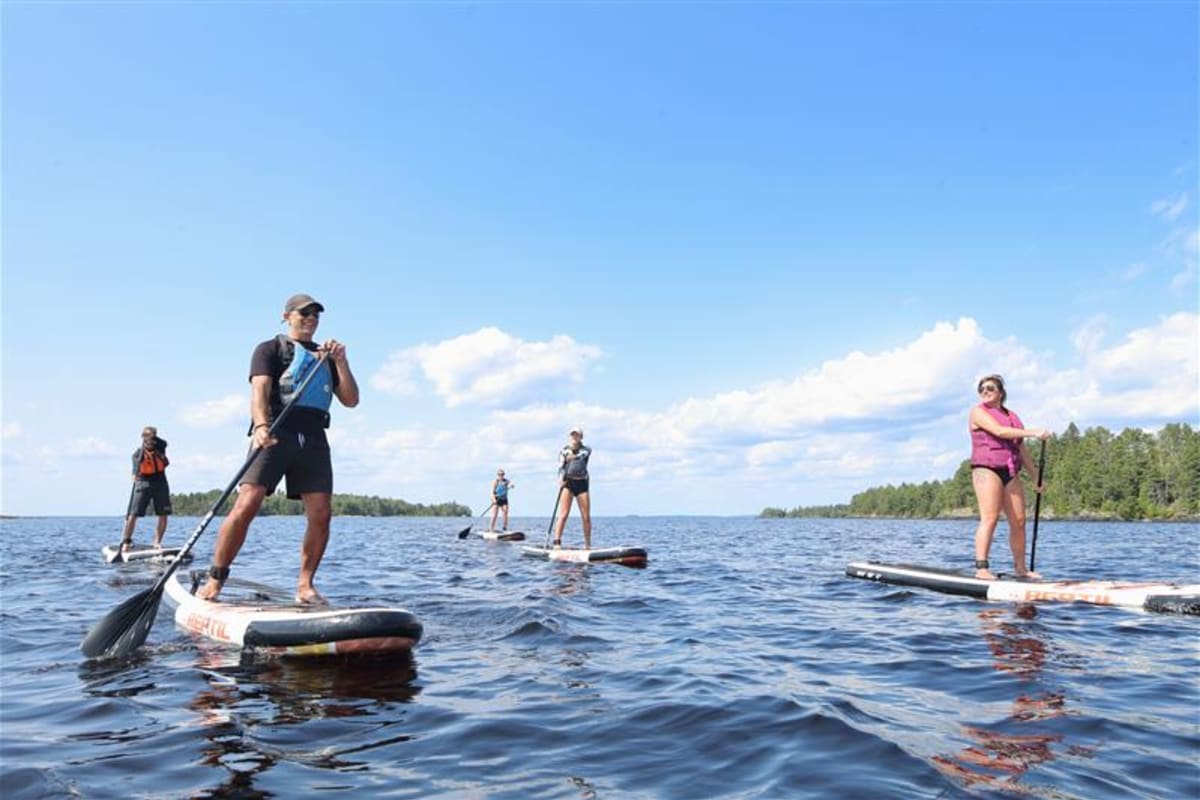 Groupe de personnes sur des planches à pagaie.