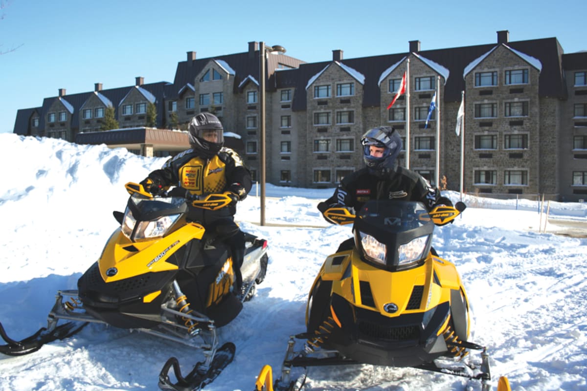 Motoneigistes devant le Doubletree en hiver.