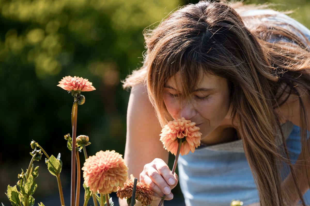Adolescente sentant une fleur. 