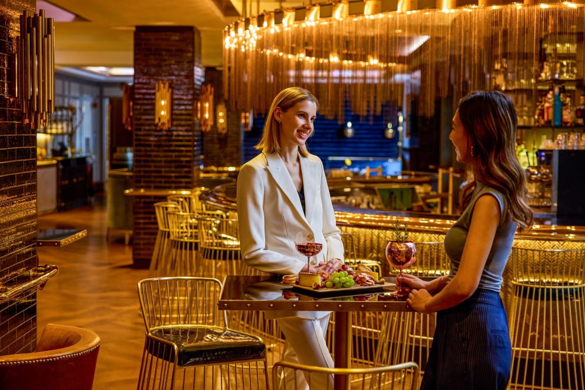 Two women at a high table at Bistro Le Sam.