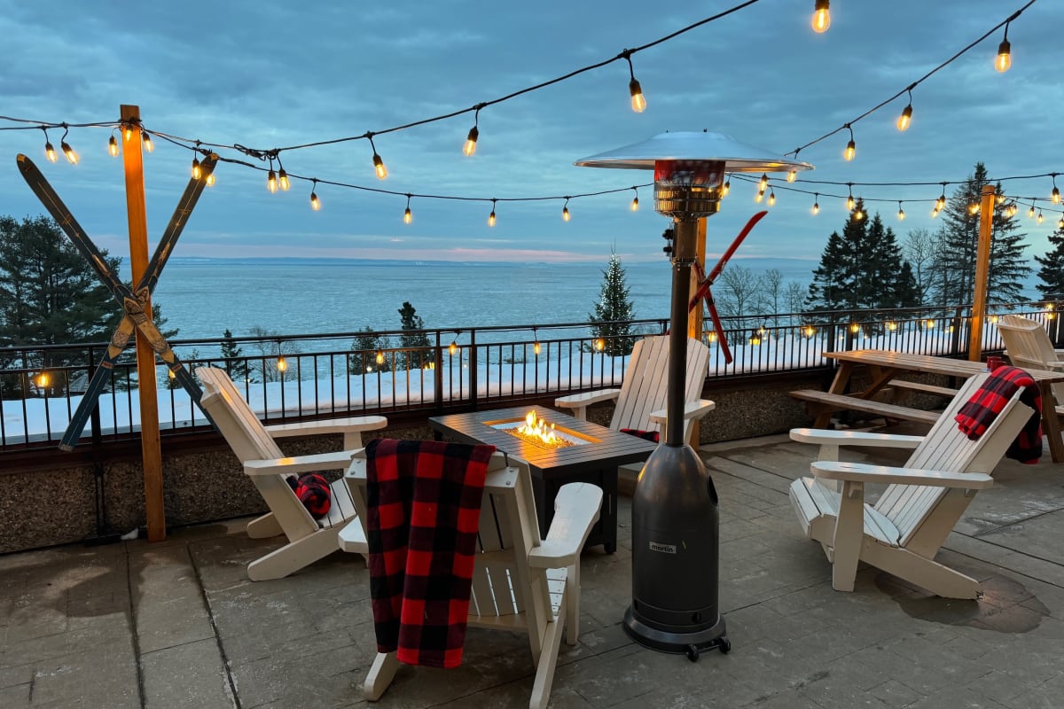 Terrasse hivernale du Manoir Richelieu, avec chaises, couvertures et foyer extérieur.