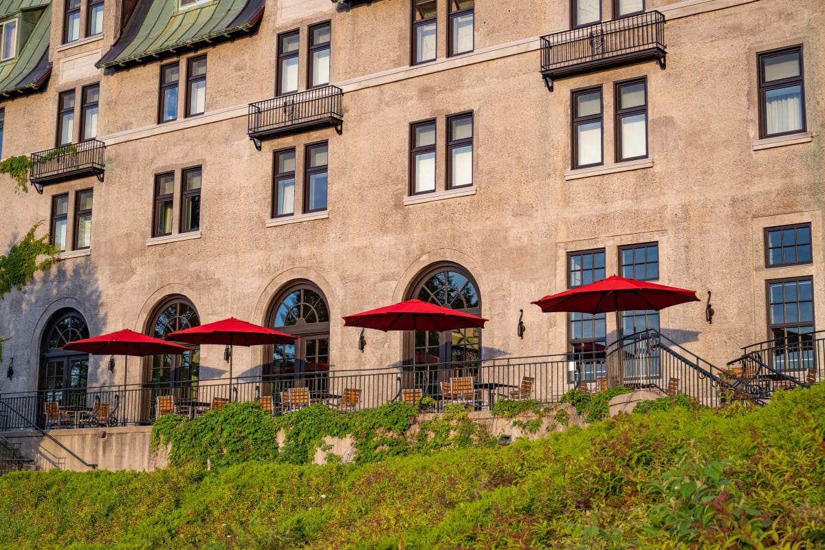 Terrasse avec plusieurs parasols rouges au Fairmont Le Manoir Richelieu.