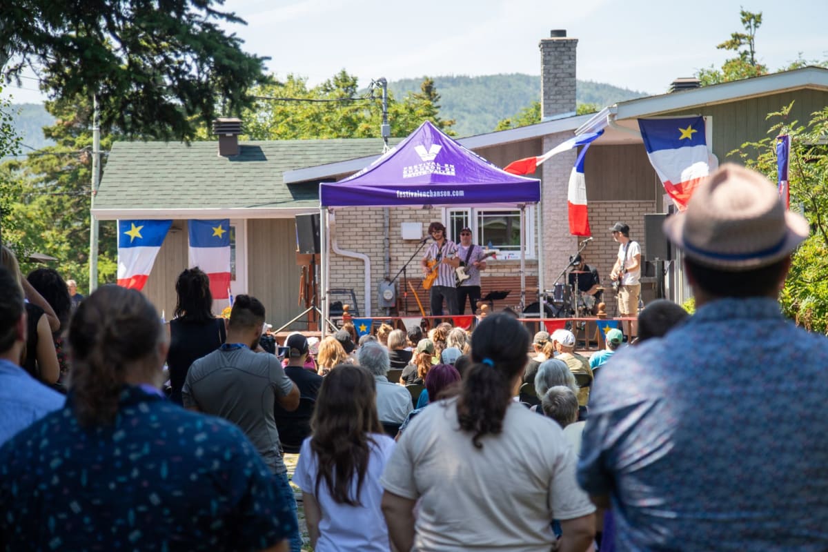 Crowd in front of a show happening on a patio next to a house.