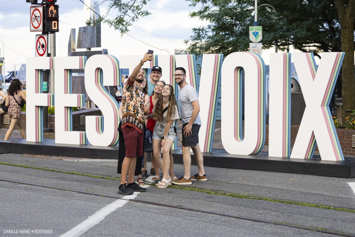 Des amis prennent une "selfie" devant FestiVoix de Trois-Rivières.