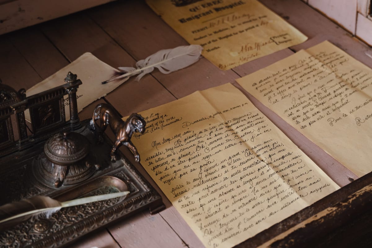Plumes pour écrire avec feuilles jaunies manuscrites.
