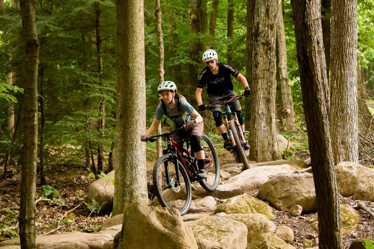 Deux personnes en train de faire une descente de vélo de montagne.