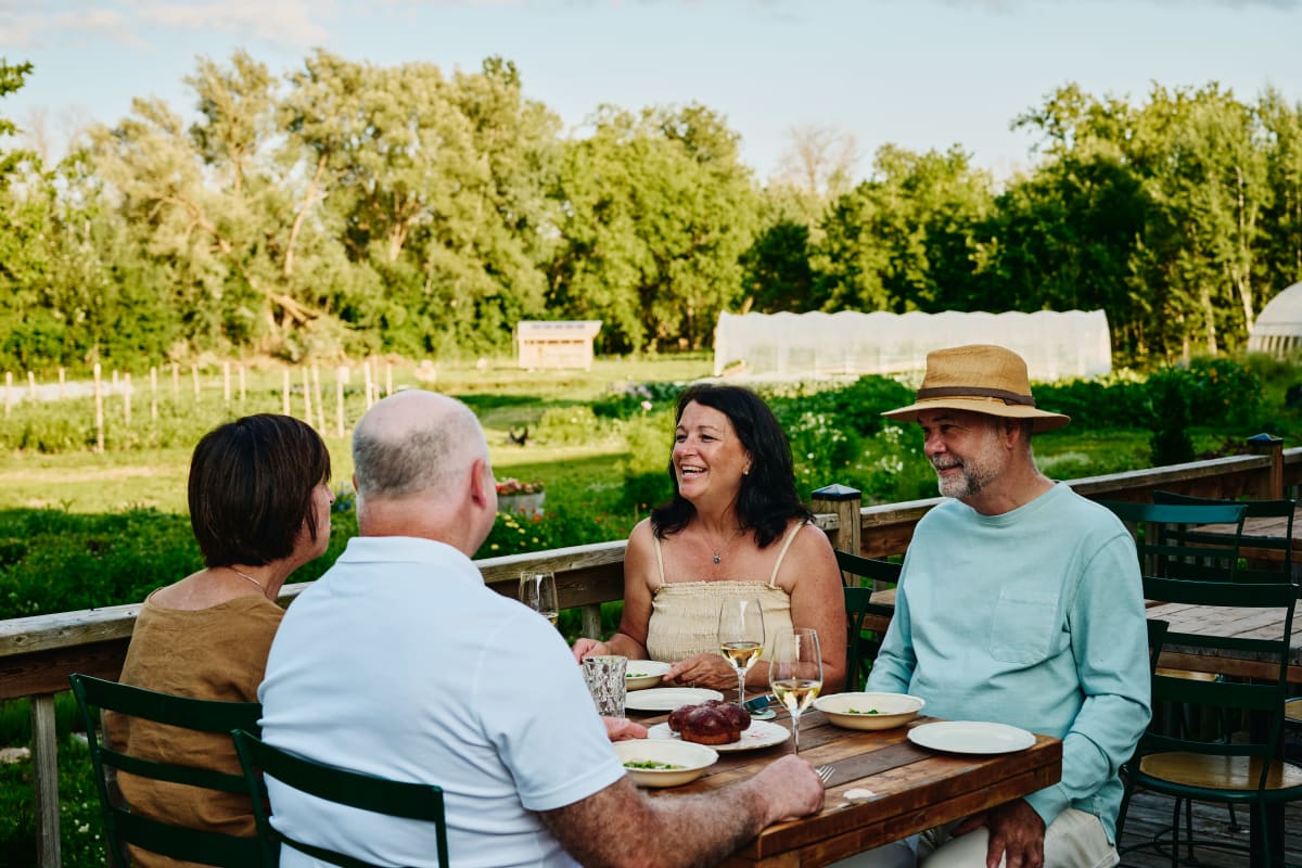 Quatre personnes attablées sur une terrasse par une belle journée d’été à l'Espace Old Mill.