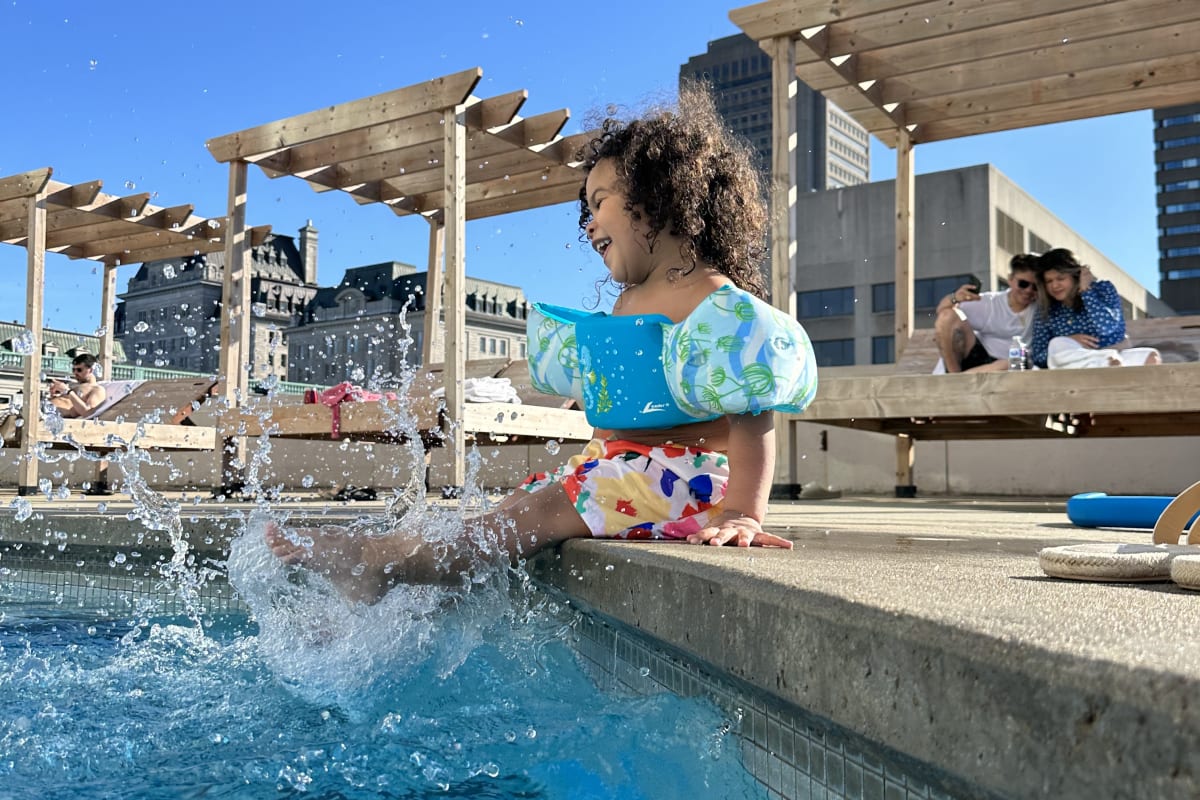 Petite fille au bord de la piscine extérieure au Hilton Québec.