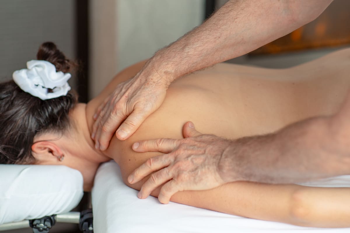 A woman getting a back massage at the Centre de santé l’Estuaire at the Hôtel Levesque