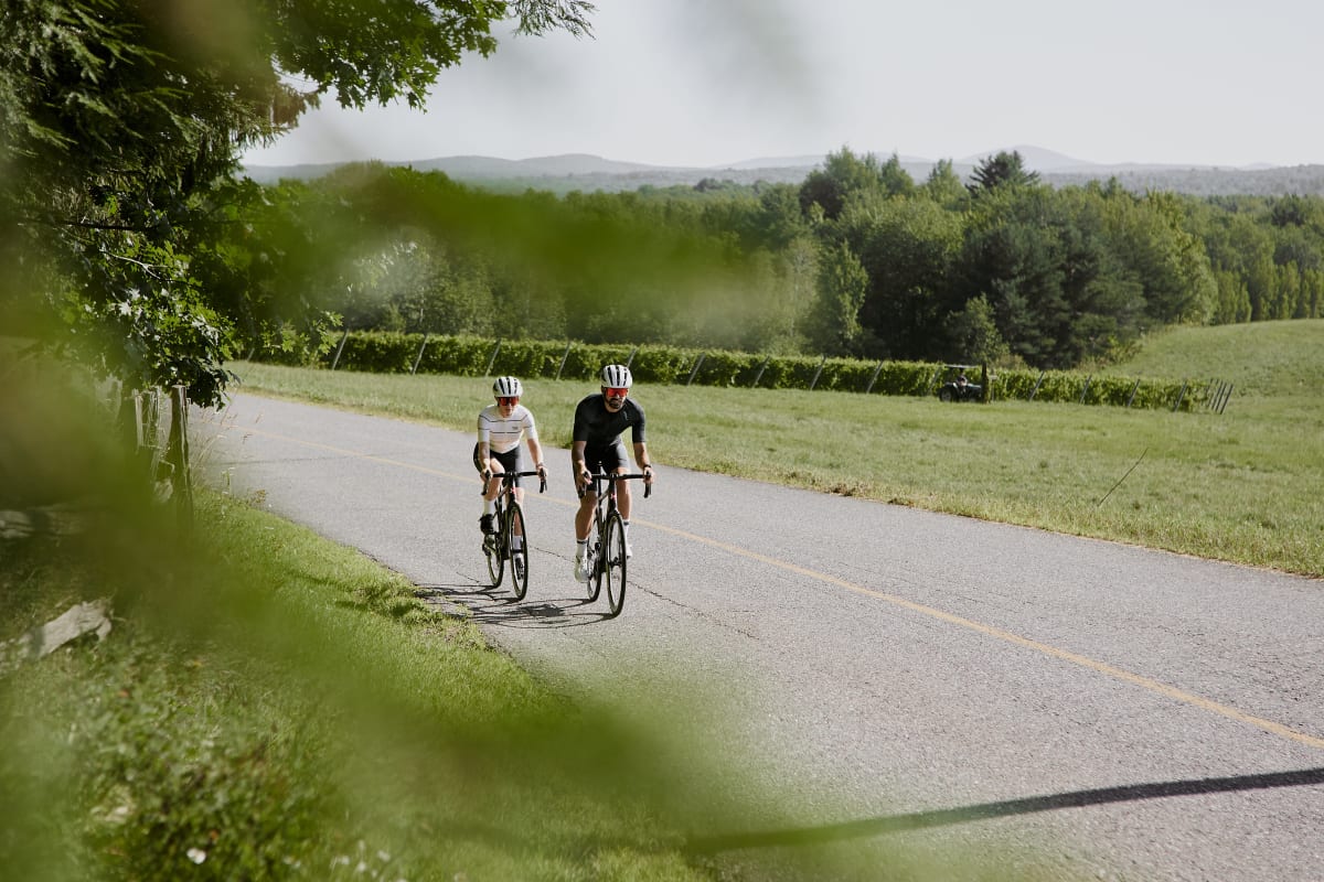 Deux personnes en vélo sur une route asphaltée.