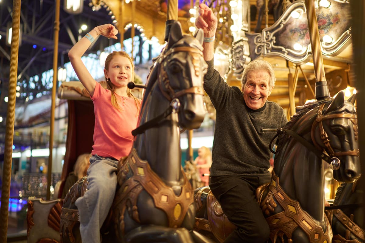 A little girl and a man on a carousel.