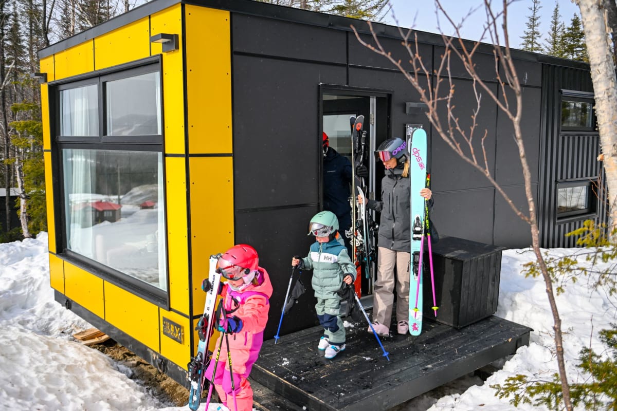 Famille à l'extérieur d'un hébergement Coolbox au Mont Grand-Fonds.
