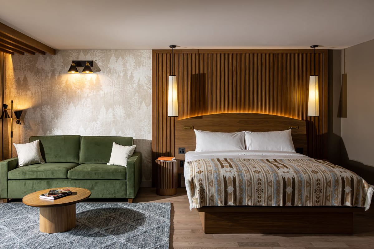 Grande chambre à l'Hôtel-Musée Premières Nations, avec lit et divan.