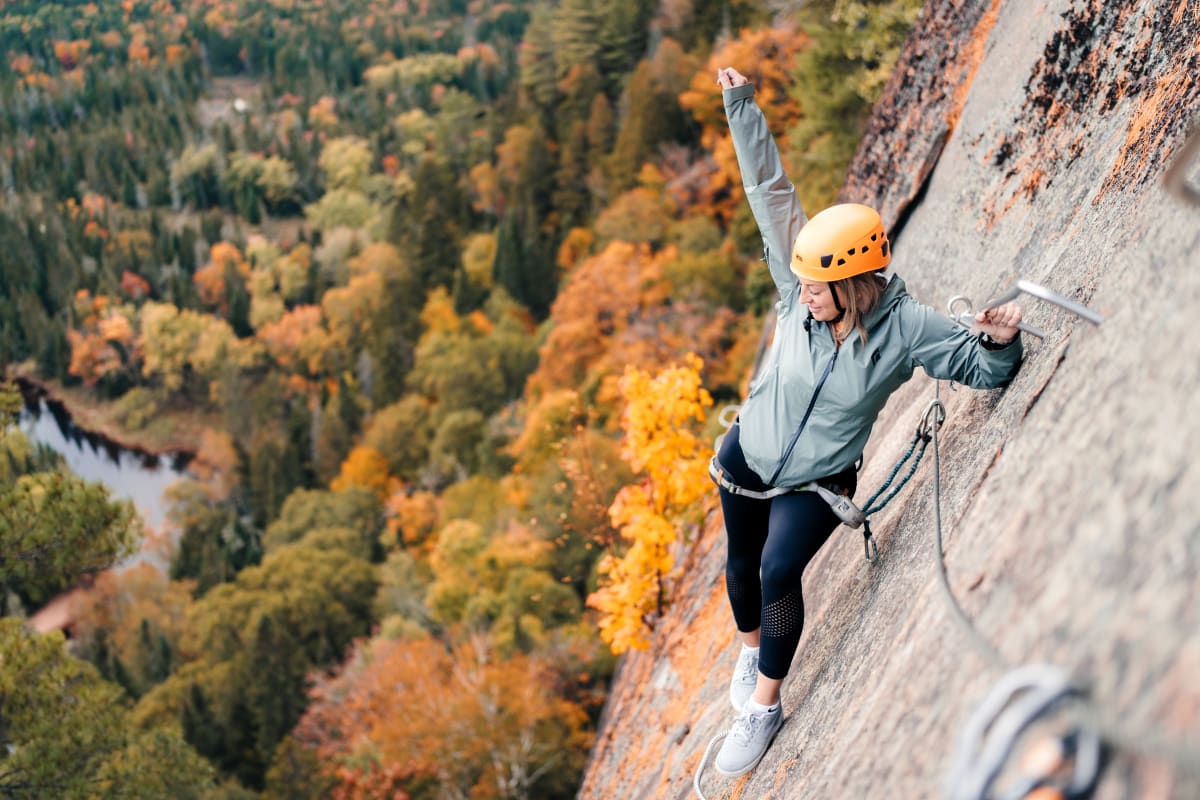 Femme sur le parcours de via ferrata l'automne au parc national du Mont-Tremblant.