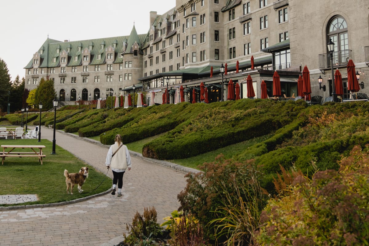 Femme avec un chien devant le Fairmont Manoir Richelieu