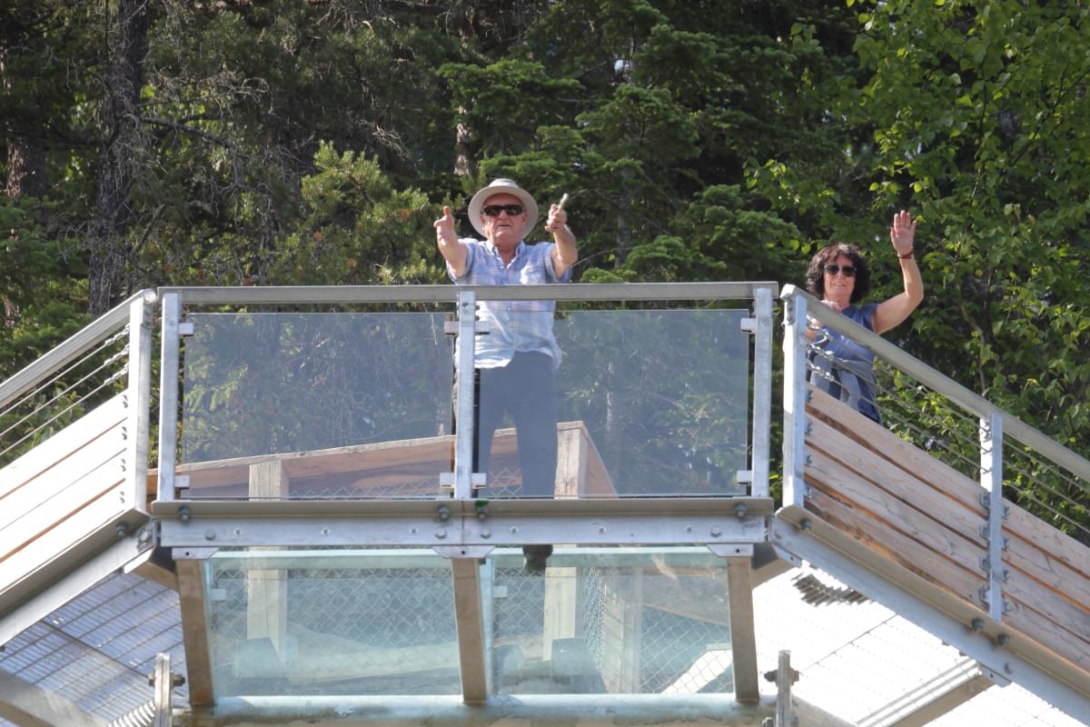 Deux visiteurs sur le plancher de verre au Parc le Trou de la Fée